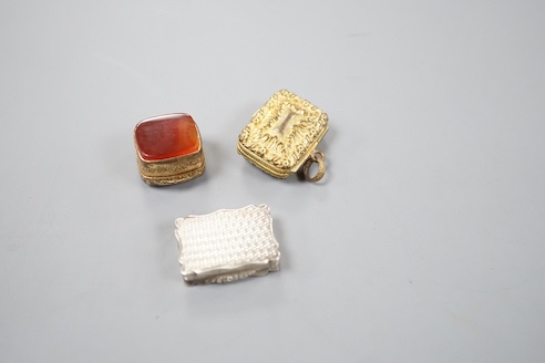 A Victorian engraved silver shaped rectangular vinaigrette, Alfred Taylor, Birmingham, 1850, 27mm and two other gilt metal vinaigrettes, one with inset agate lid.